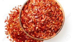 dried red chilli flakes in the wooden bowl, isolated on white, top view dried red chilli flakes in the wooden bowl, isolated on white background
